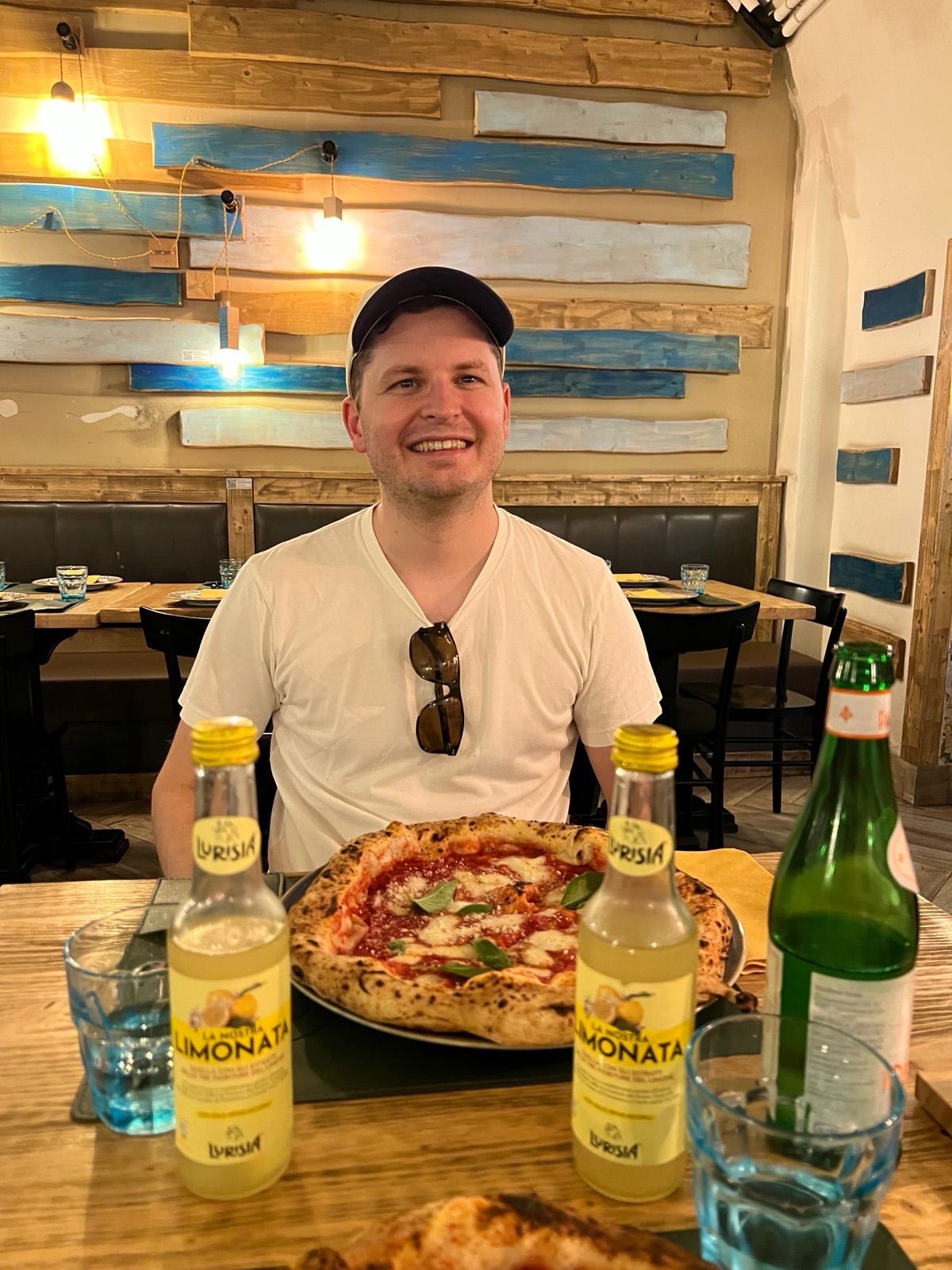 Vegard at a restaurant table with a pizza.